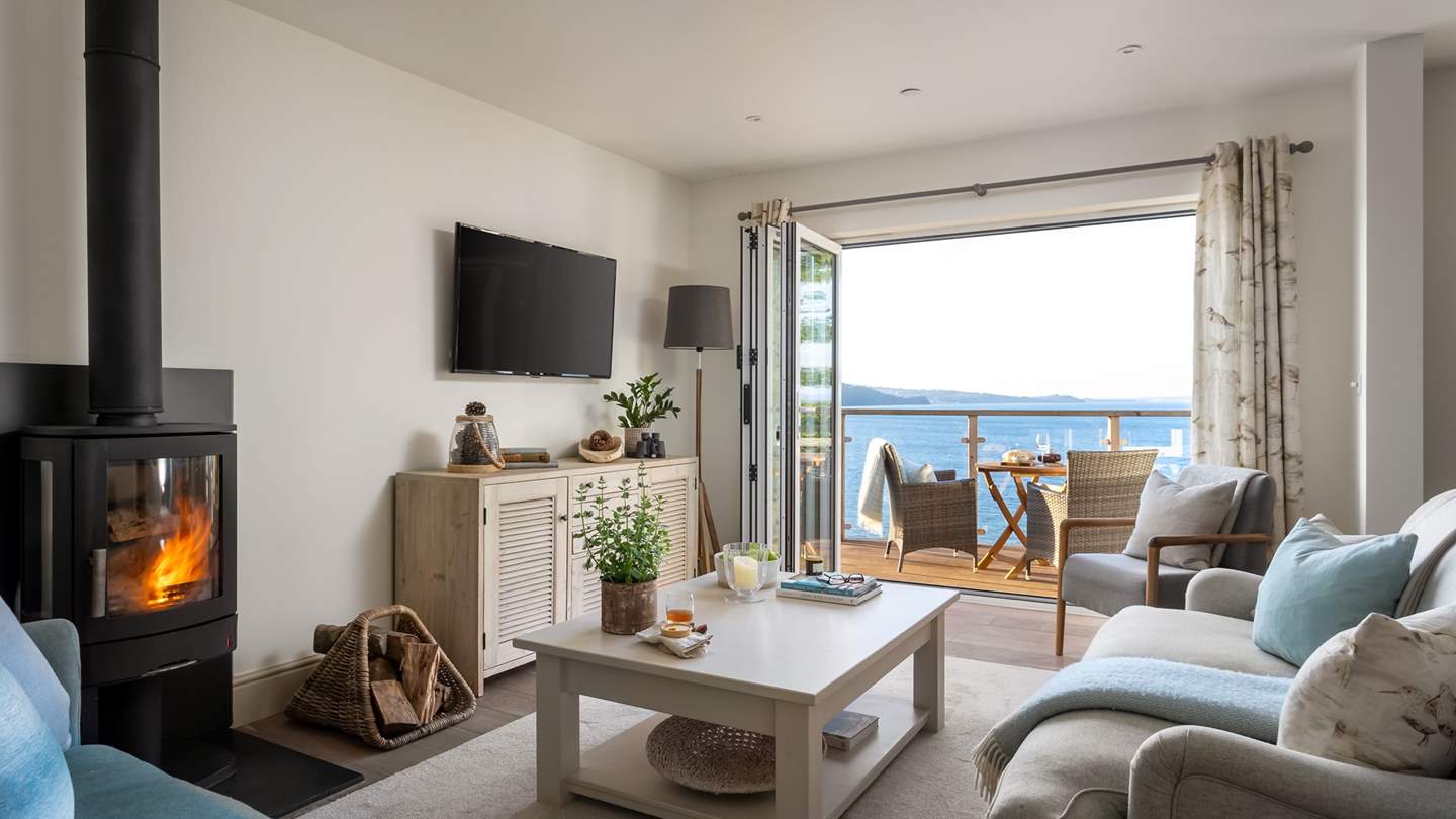 Embracing a soothing palette with organic textures and tasteful artwork, the living room is framed with bi-fold doors leading to a suntrap terrace