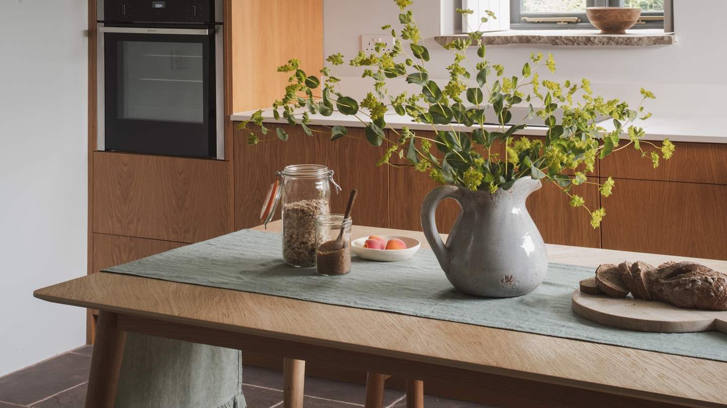 For banquets and brunches, a teak wood dining table with two benches awaits