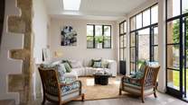 Crittall-style doors look onto the lawned garden and rolling hills beyond