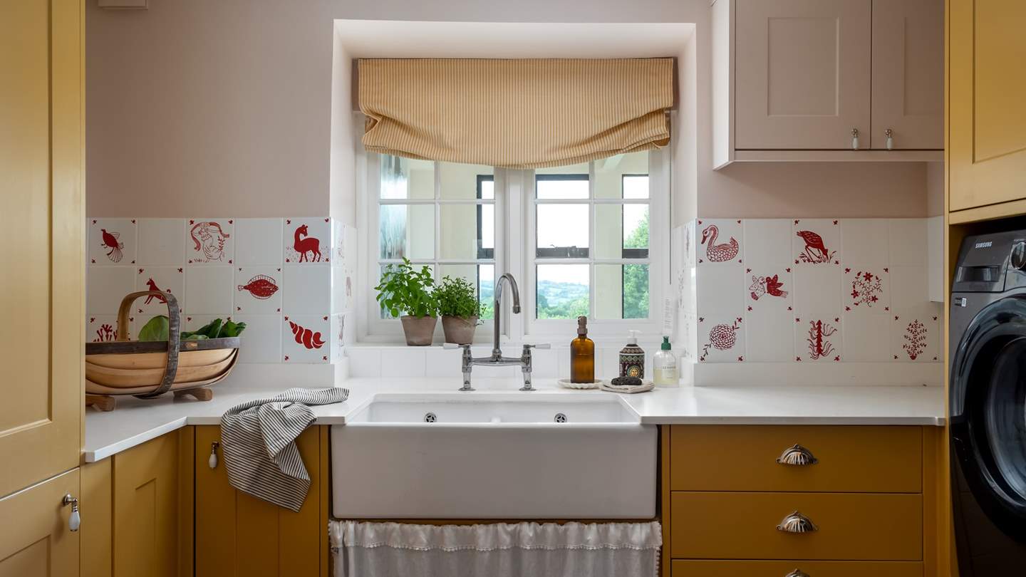 Just next door is the darling pantry, adorned with adorable picture tiles by Maude Made