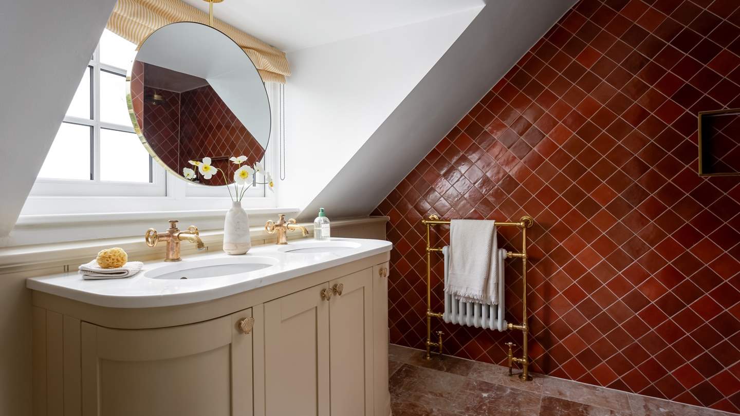 The en suite is complete with a quarry-tiled walk-in shower and a brass rainfall head