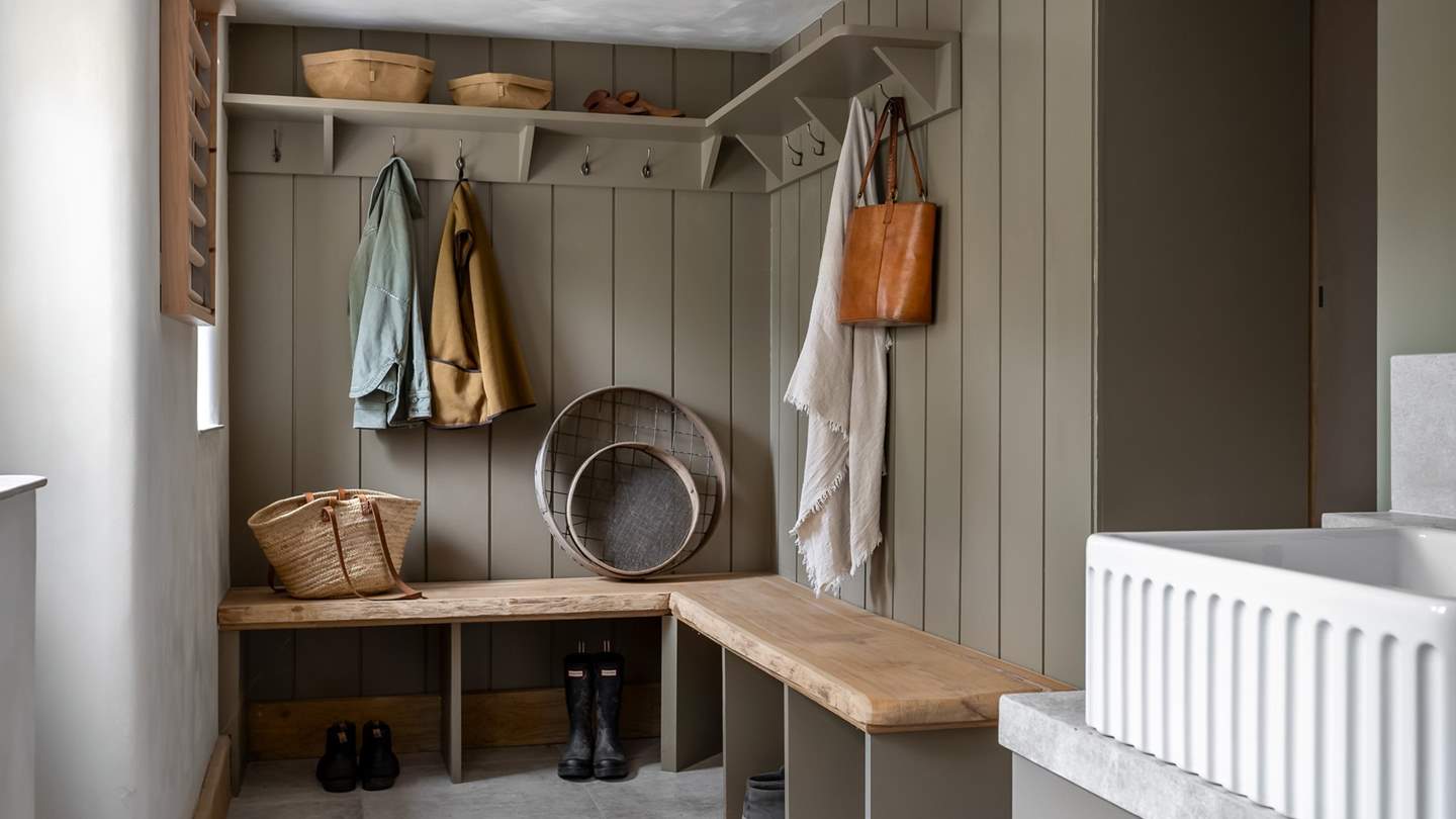Olive green tones reign in the bespoke boot room