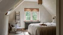 The master bedroom promises spellbinding slumbers beneath the breath-taking limewashed, vaulted ceiling...