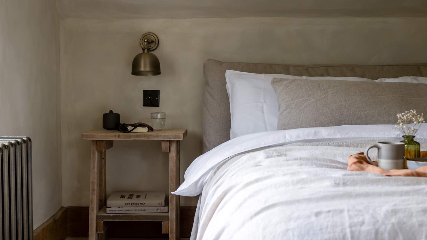 This bedroom boats a king-sized bed enveloped in cloud soft linens...