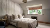 With a wood panelled feature wall and rattan accessories, the second bedroom promises calming neutral shades 