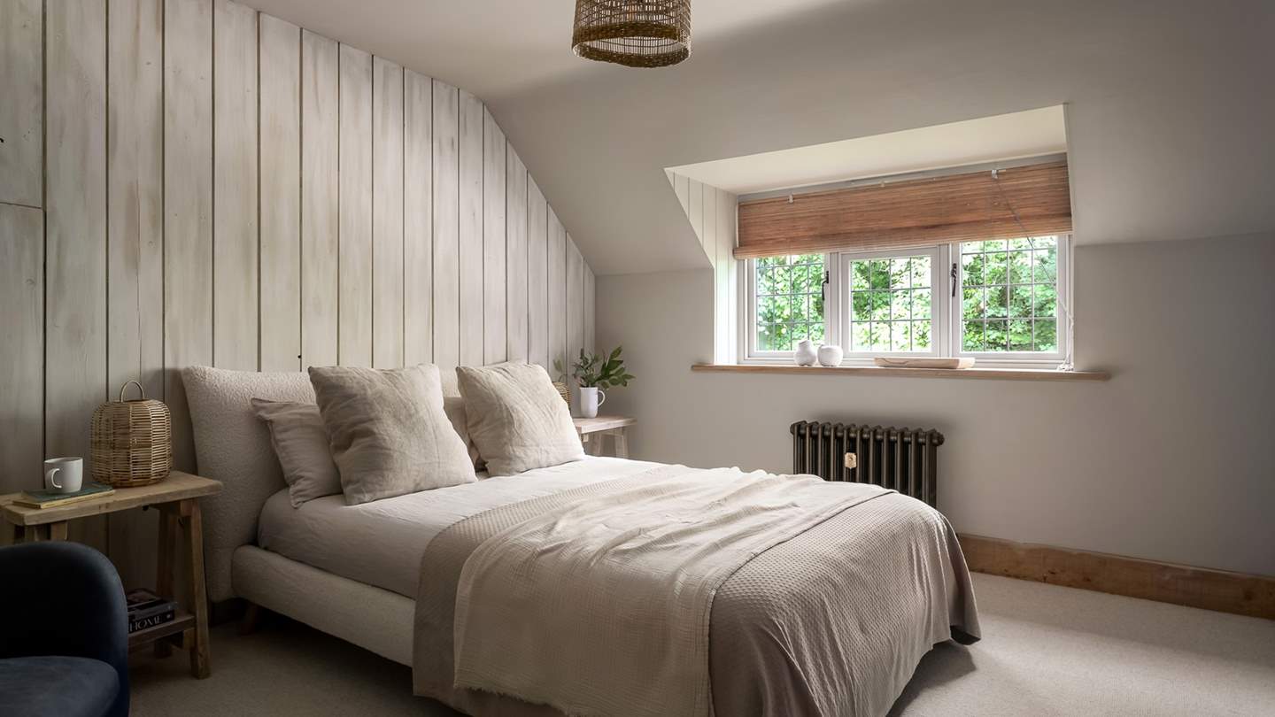 With a wood panelled feature wall and rattan accessories, the second bedroom promises calming neutral shades 