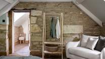 Beside rustic exposed stone lies a quirky hanging rail for stowing belongings...