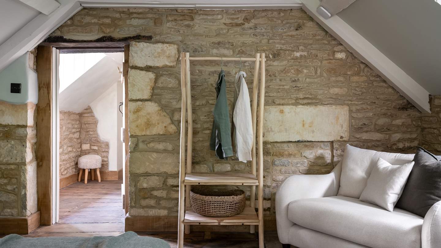 Beside rustic exposed stone lies a quirky hanging rail for stowing belongings...