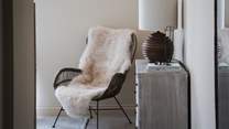 For a peaceful spot to recline, an armchair draped in soft sheepskin overlooks the garden