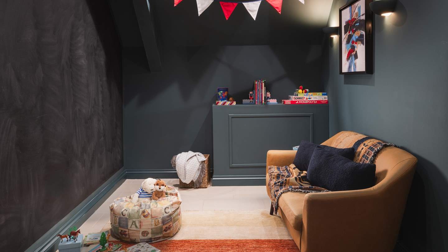 Perfect for little ones, a dedicated playroom with a child-sized sofa, bean bag chair, books and games invites, plus one entire wall is a chalkboard for the artistically minded
