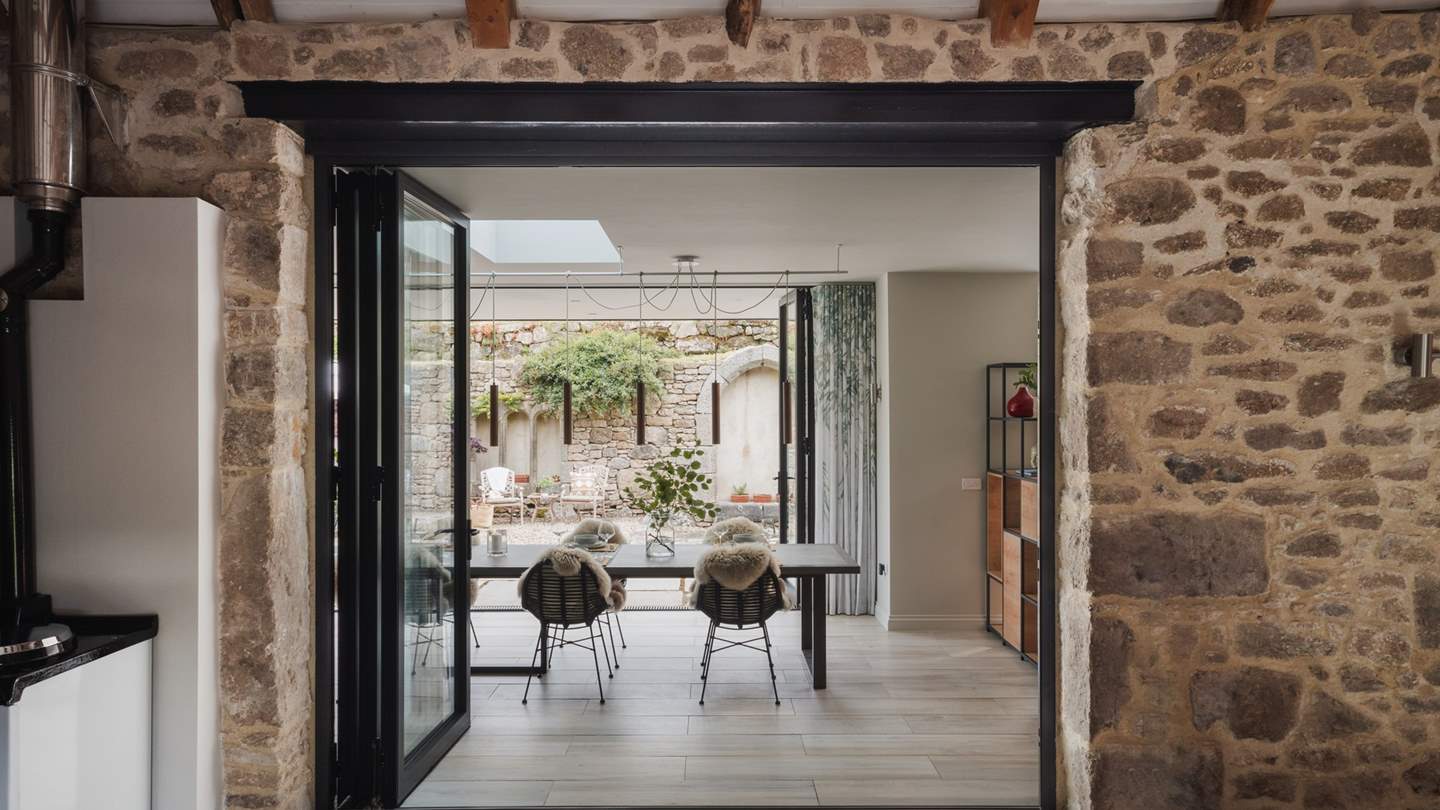 Adjoining the living area through bi-fold glass doors, a large sunroom presents an elegant dining area 