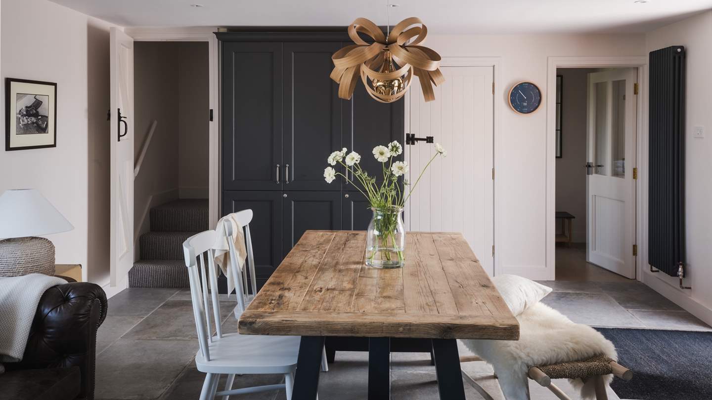 This space features a distressed country table and chocolate brown leather chesterfield and is a beautiful segue to the ground floor living areas