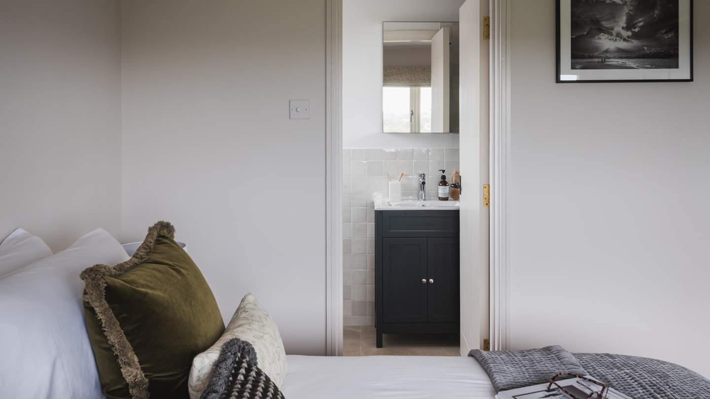 This bedroom benefits from its own ensuite bathroom, complete with a walk-in shower with a rainfall shower head