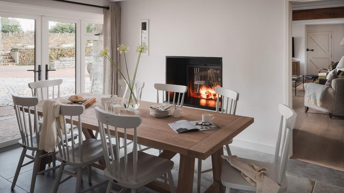 With views over the sheltered courtyard through patio doors and the warmth of a double-sided wood burning stove, this space is a welcome sanctuary in all seasons 