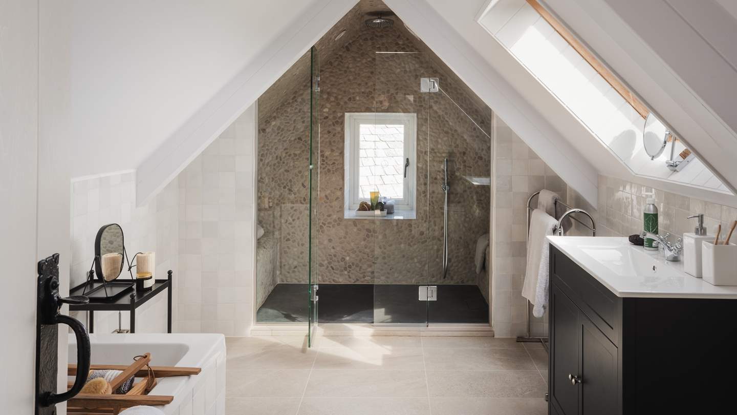 Full of charm, this bedroom also boasts its own spacious ensuite bathroom, where both a large walk-in shower with a rainfall head and a separate bath reside