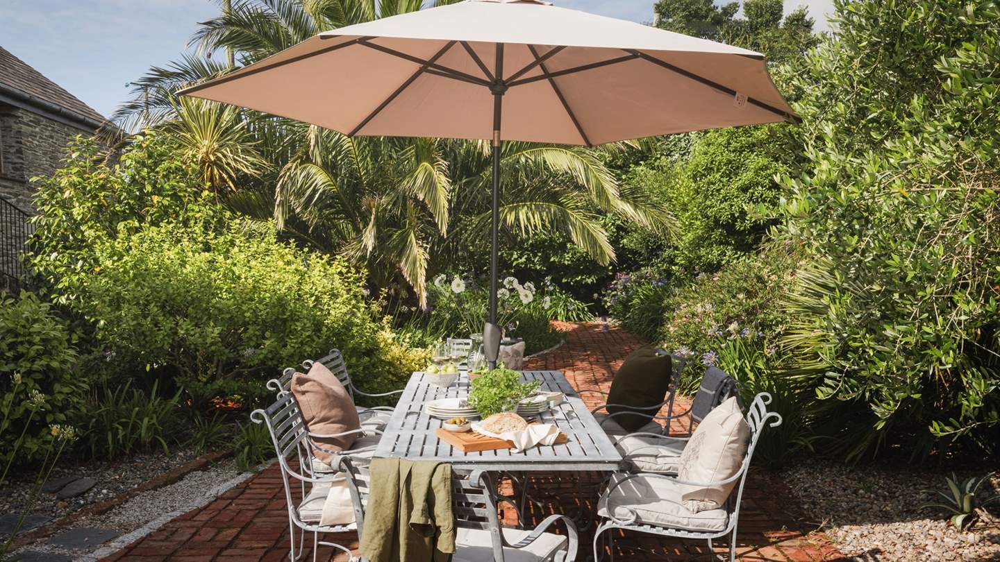 Soaking up a sun-kissed setting and affording rural vistas, it features a dining table for eight and comfortable outdoor lounge furniture, with an L-shaped sofa and a cosy armchair