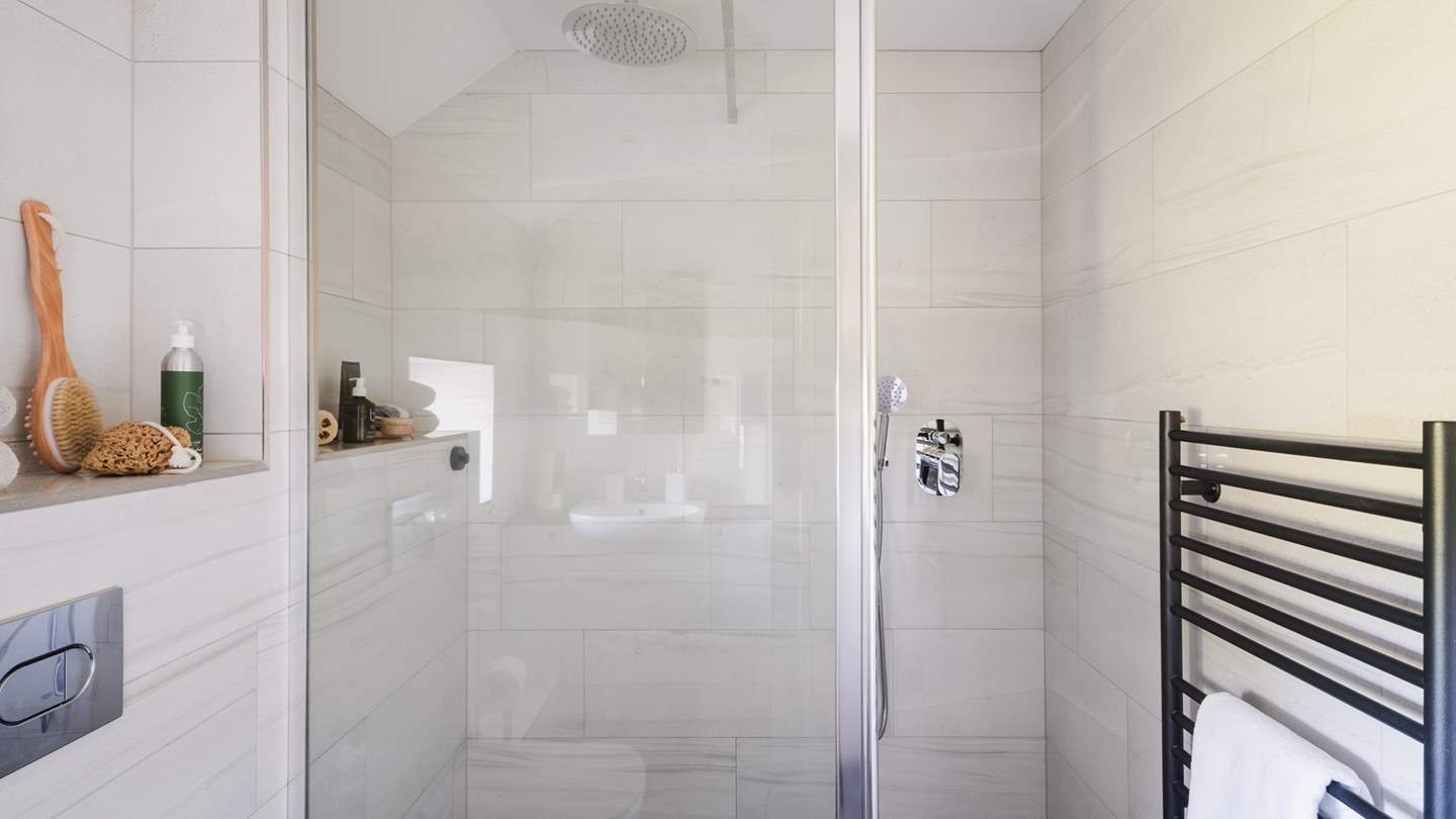 For utmost comfort, this bedroom is paired with an ensuite, featuring a walk-in shower with a rainfall shower head