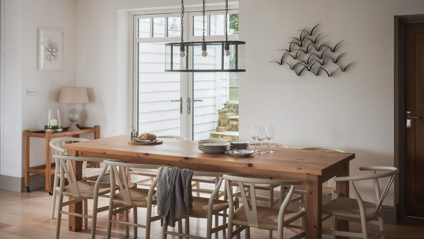 The perfect space for family and friends to come together over lovingly crafted cuisine, a dining table resides beneath pendant lighting 