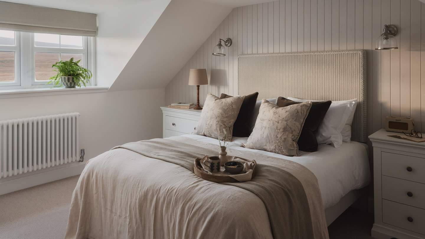 Swathed in tones of ecru, the master bedroom boasts a grand king size bed with a rattan headboard