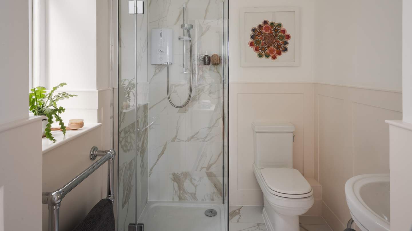 This bedroom also features a sweet ensuite shower room in soothing tones, complete with a shower