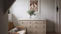 A chest of drawers and vanity allow space for belongings