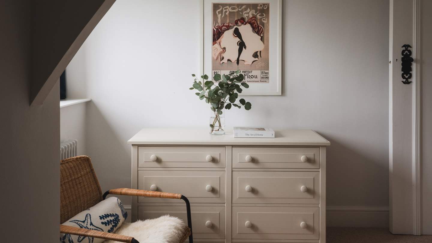 A chest of drawers and vanity allow space for belongings