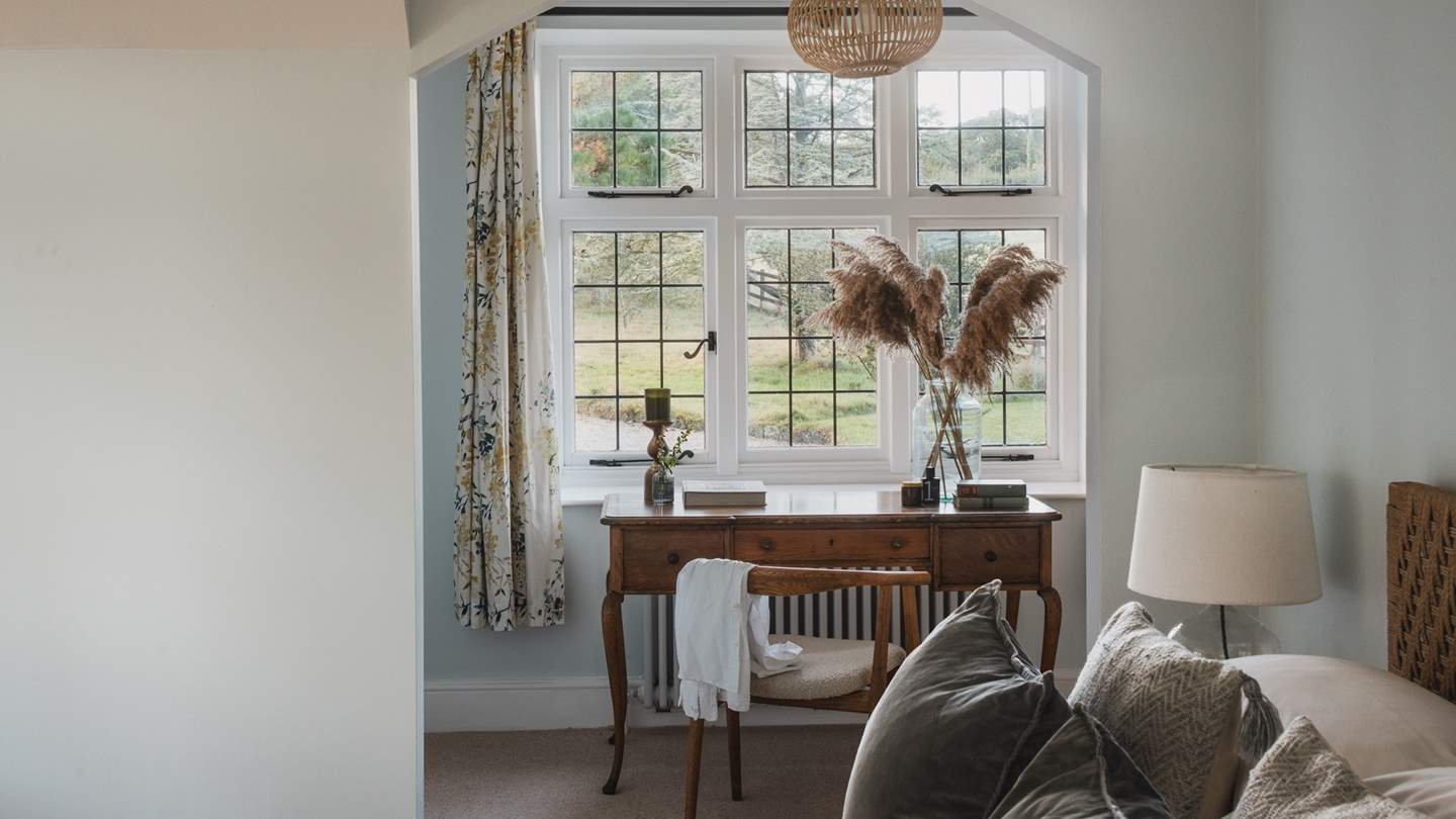 A vintage writing desk and boucle chair offer space for quiet moments