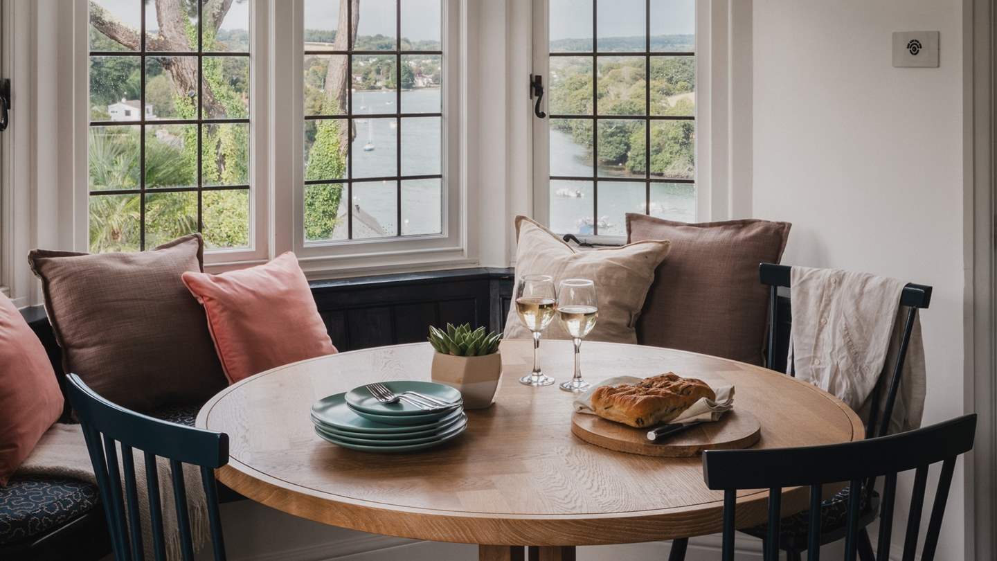 The kitchen features a breakfast table with curved banquette seating and three chairs
