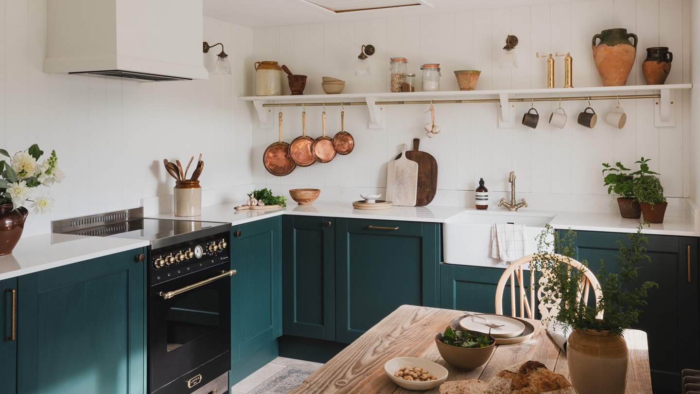 The kitchen features handcrafted, evergreen cabinetry harmonised with antique brass details and a quartz worktop