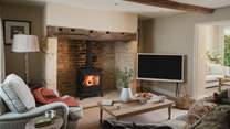 Set within an original fireplace and period mantel, a wood burning stove radiates warmth in the cooler months