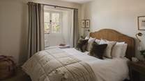 The second bedroom with a rattan king size bed promises equally halcyon garden views 
