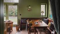 The light-filled garden room is beautifully adorned with wood panelling in Farrow and Ball’s Calke Green