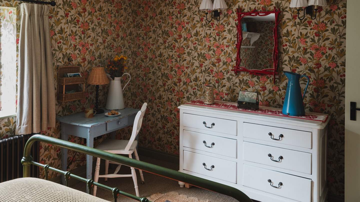 Two bedside tables, a chest of drawers, hanging hooks and a small dressing table offer plenty of storage space