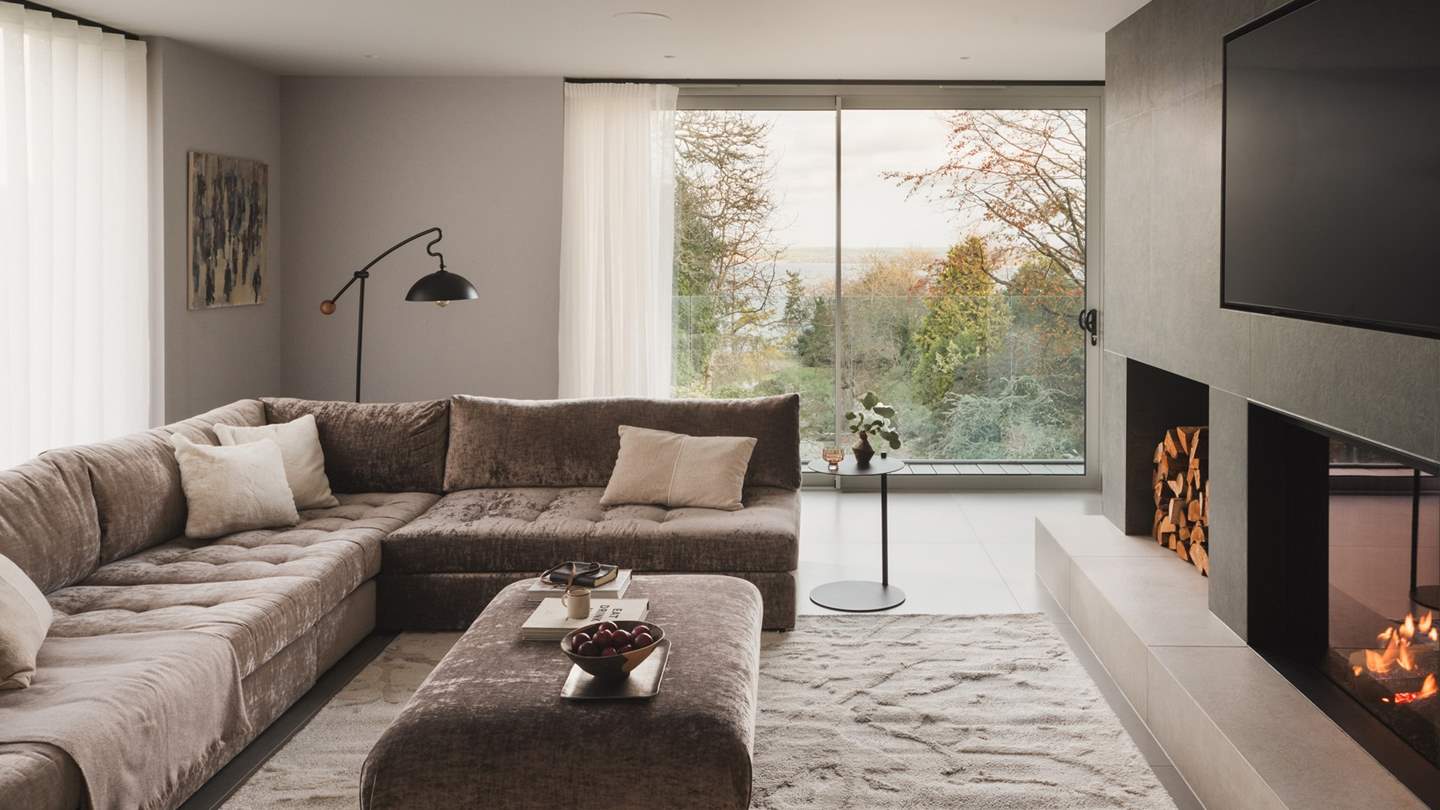 With an exquisite ocean aspect and verdant garden views, the living room is an especially serene space for relaxing and gathering together