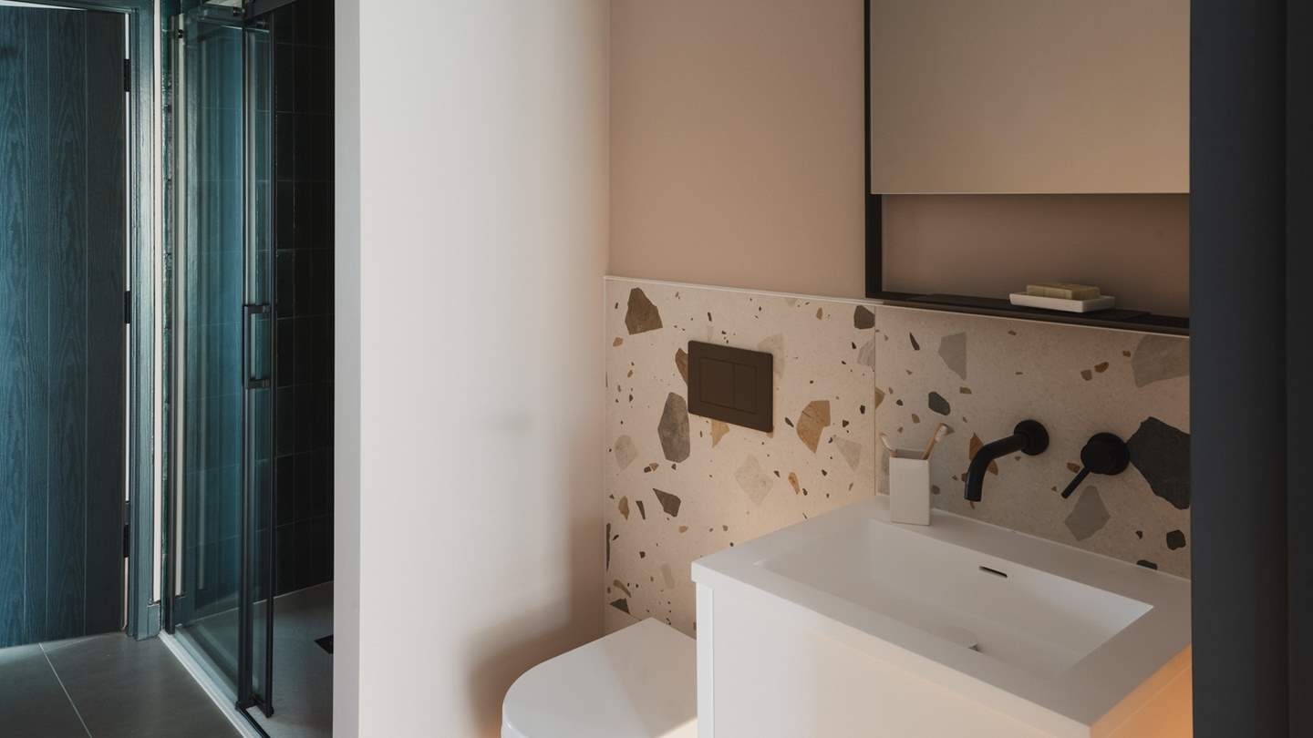 This bedroom also has a beautiful ensuite with a walk-in shower adorned in ocean-hued tiles