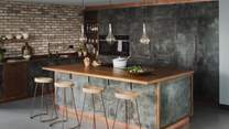 Beautifully bespoke, the industrial style kitchen features handcrafted cabinetry and a complementing breakfast island