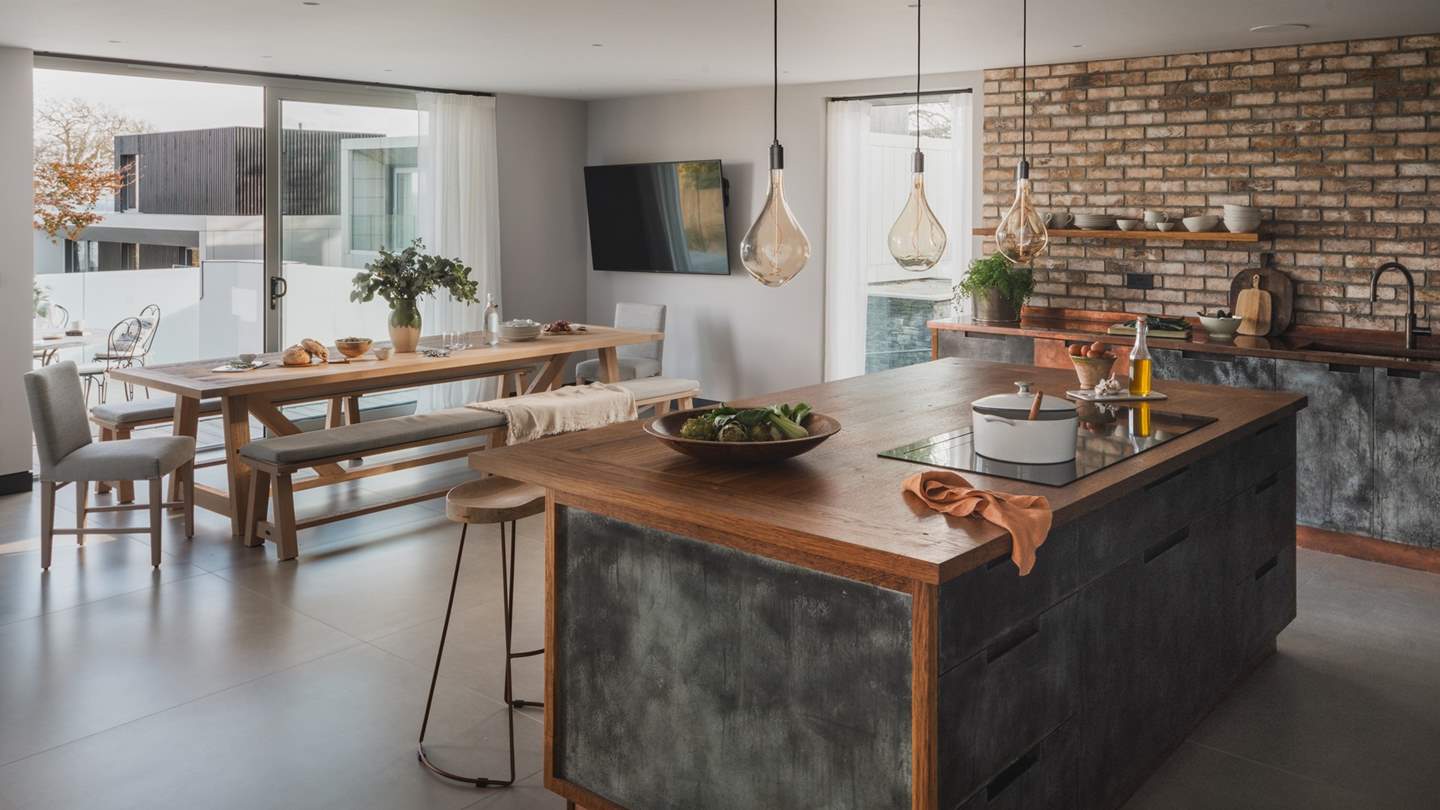 Adjoining the kitchen, the open-plan dining room is home to a banquet-style table with bench seating and chairs