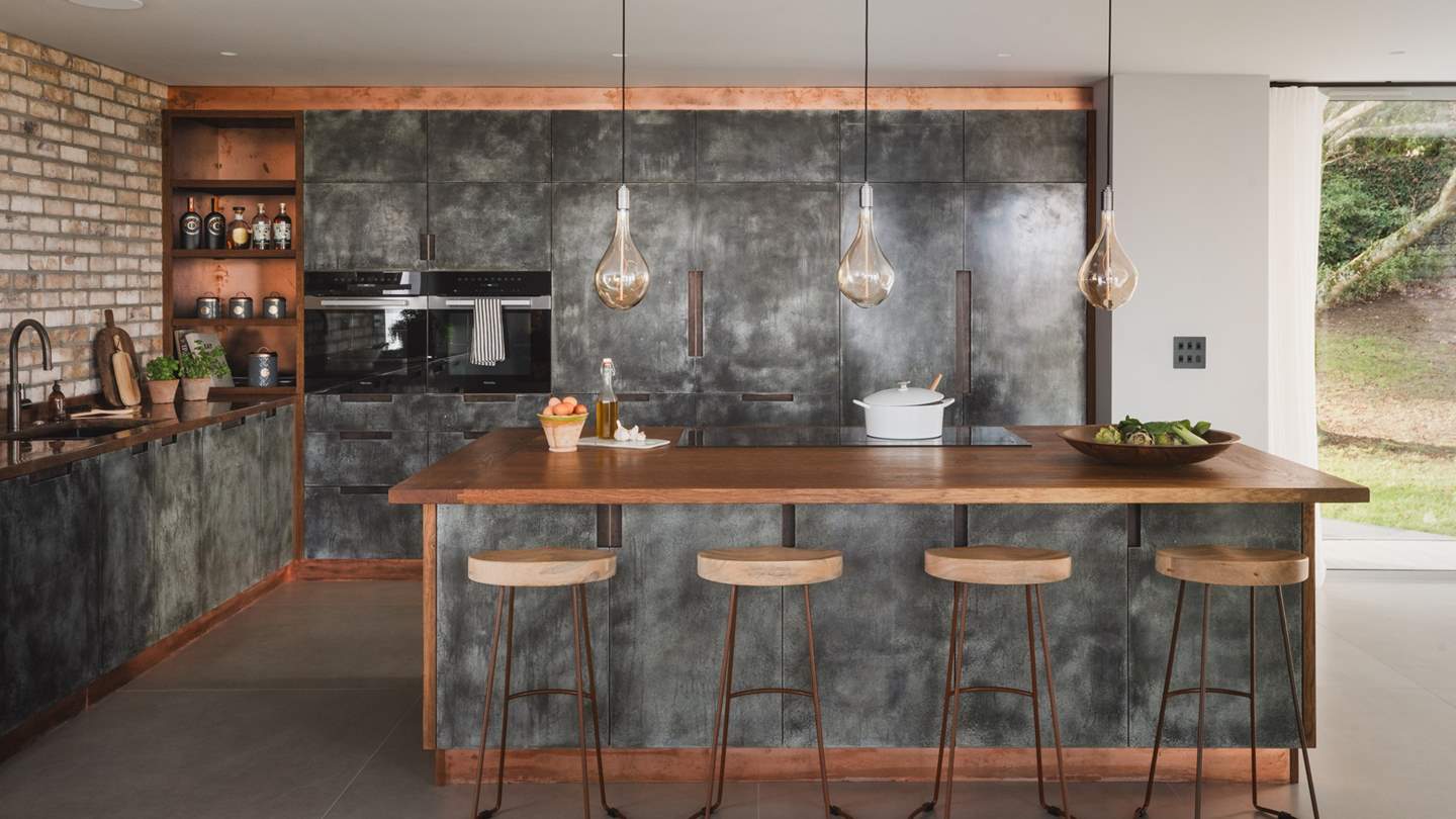 In a beautiful open-plan design, the kitchen and dining area proposes slow mornings and candlelit evenings sharing feasts and conversation