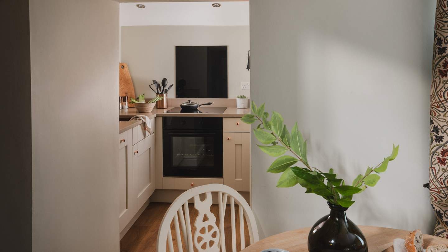 Tucked within a sweet nook beyond the dining space, uncover the snug kitchen in a modern Shaker style