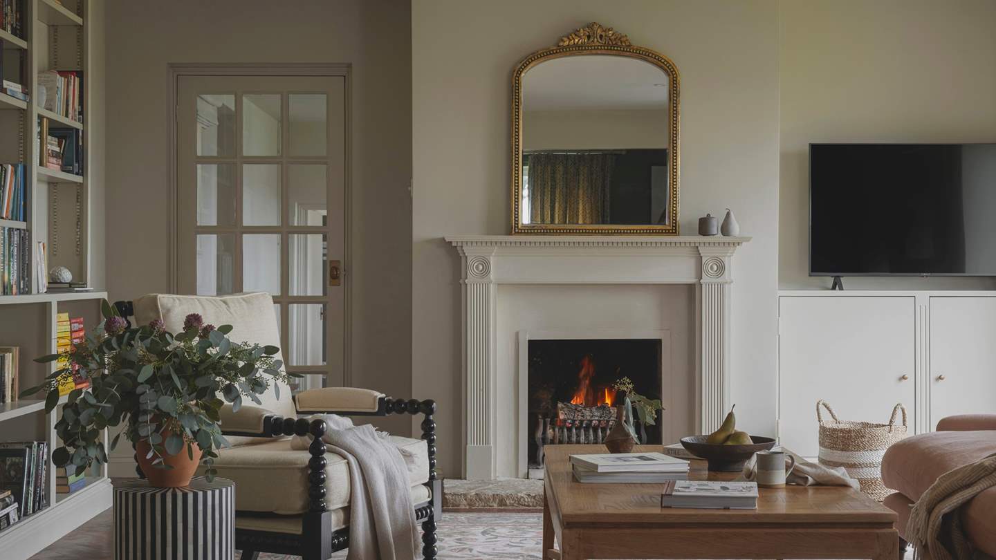 Beckoning for comfort are a three-seater, feather-filled sofa in rose and a heritage armchair with spool-turned woodwork