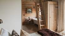 . A wooden ladder leads to a cosy mezzanine cabin for two, whilst adjacent is the wood-clad bathroom suite