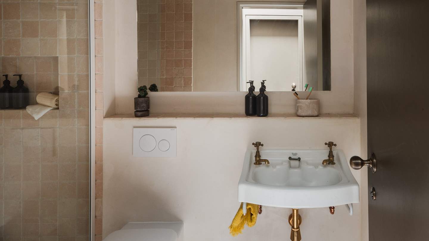 In addition, there is a shower room, embellished with pink tumbled marble and antique brass fittings