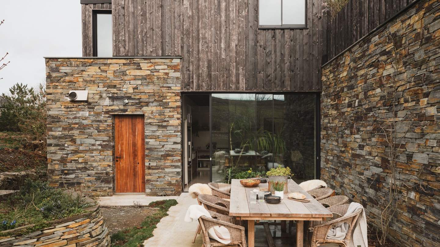 Draw open the kitchen’s sliding doors on the ground floor to unveil the first of the spellbinding alfresco spaces