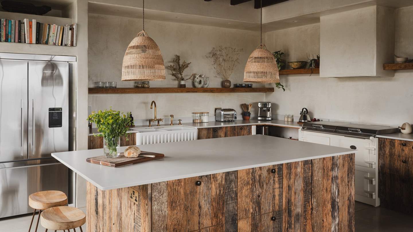 Set beneath dark wooden beams is the divine kitchen space, where reclaimed oak cabinetry and brass accents nod to the retreat’s rustic-influences