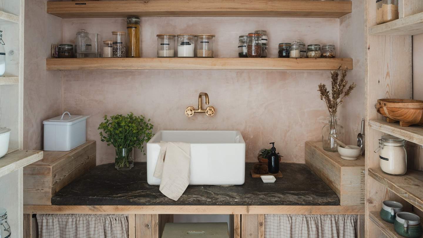 Adjacent to the kitchen is a walk-in larder, with stunning slate worktops and ample storage for locally foraged produce