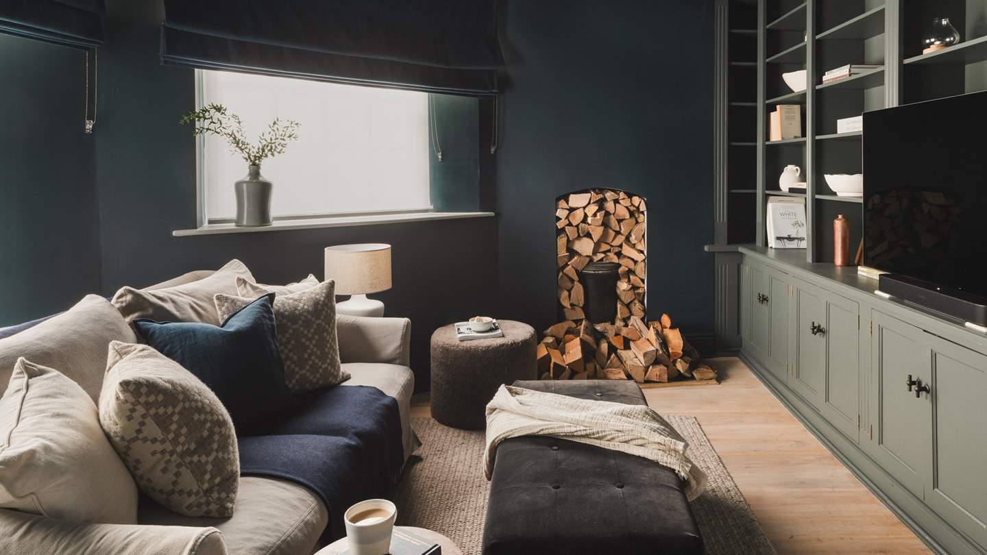 Across the hall lies the beautiful snug, decorated in dark shades for a restful ambience