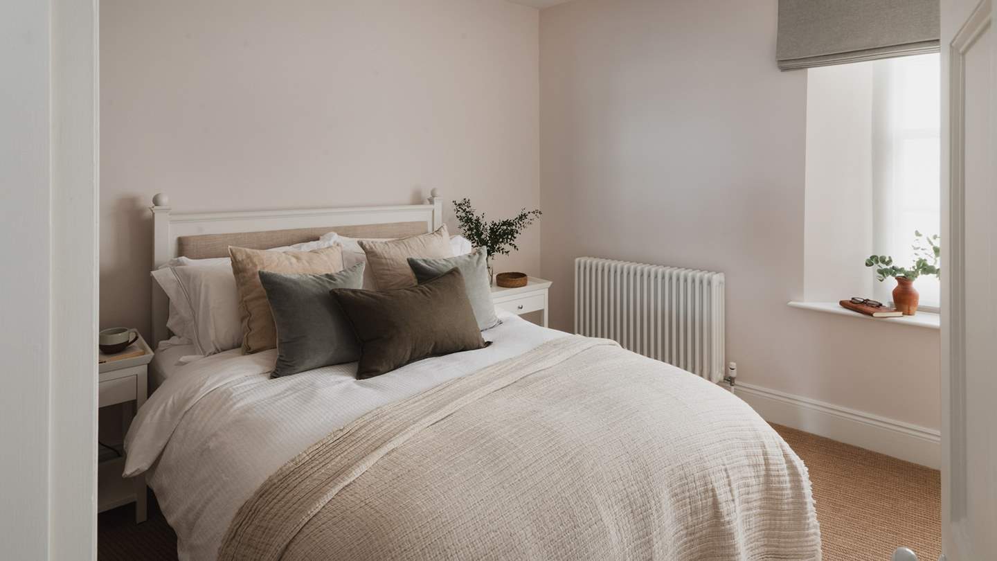 Tranquil tones adorn the third bedroom, where plump cushions and cosy throws embellish a Load double bed