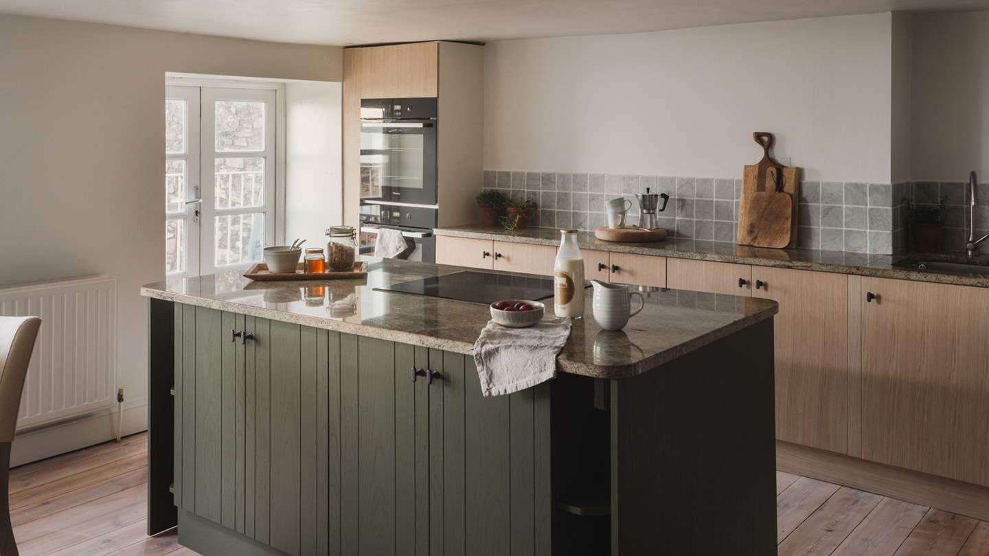 Carefully integrated into handmade cabinetry are a range of Miele appliances, complemented by generous granite worktops and an array of accoutrements.