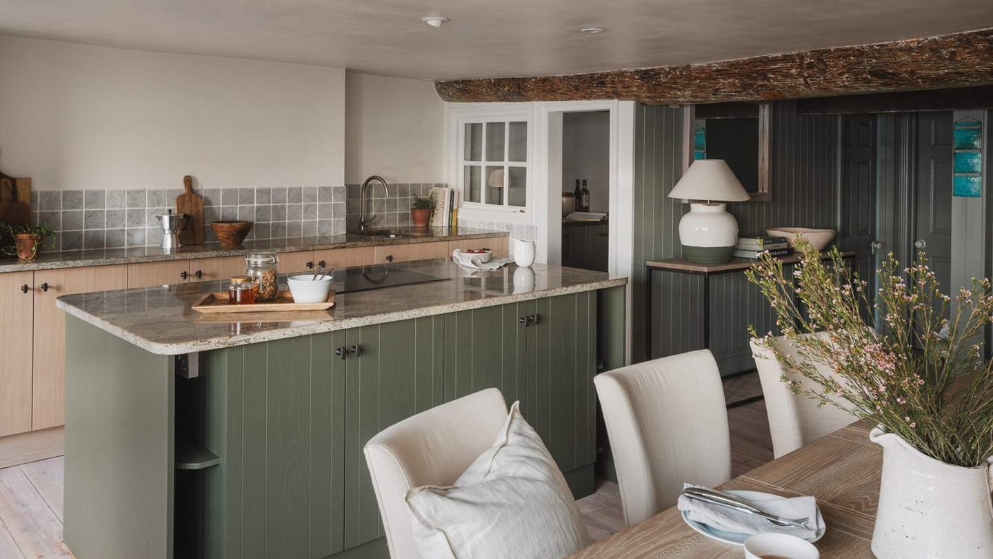 A beautiful space, the kitchen is set beneath exposed beams, offering mesmeric sea views and a modern rustic design