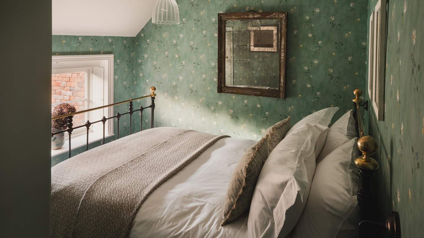 An antique brass bed is a beautiful focal point in the first bedroom 